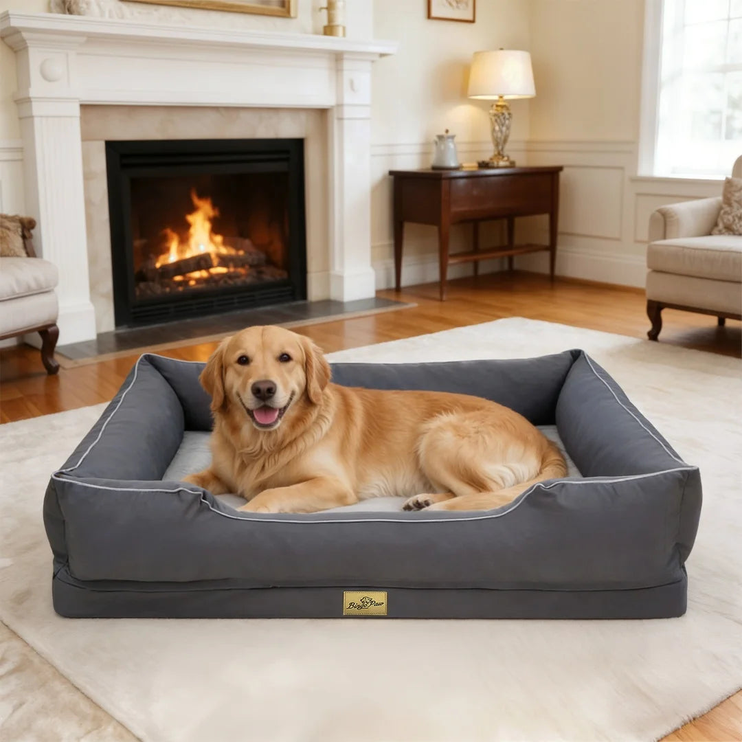 Golden retriever lying on a grey rectangular bolster dog bed in a living room with a fireplace