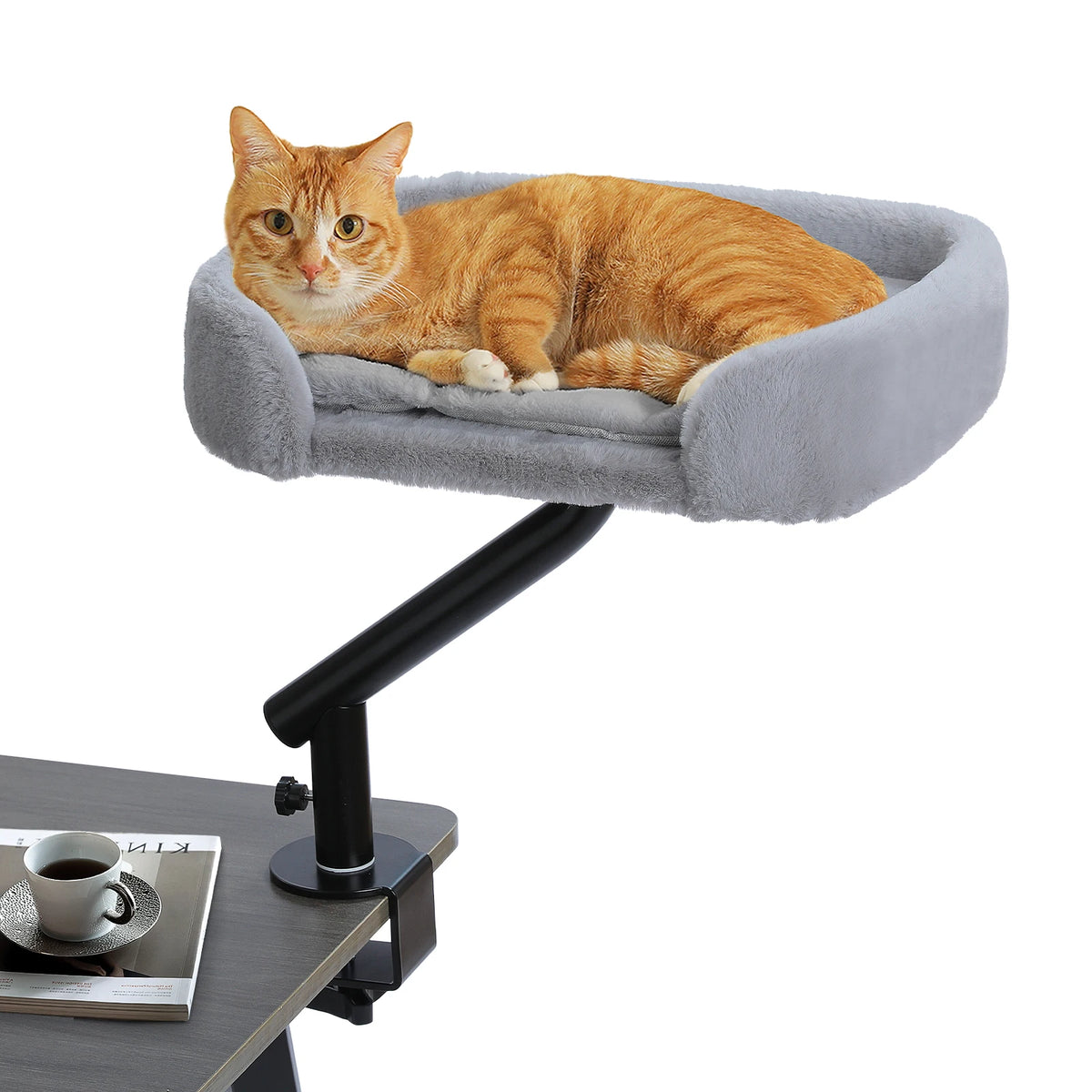 Orange tabby cat resting on a grey plush cat bed attached to a desk clamp mount