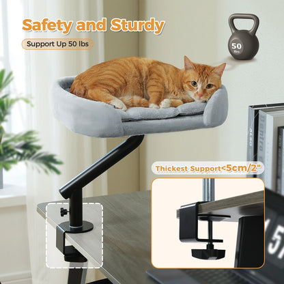 Orange tabby cat resting on a 360 rotating cat desk bed with adjustable hammock basket clamped to a desk