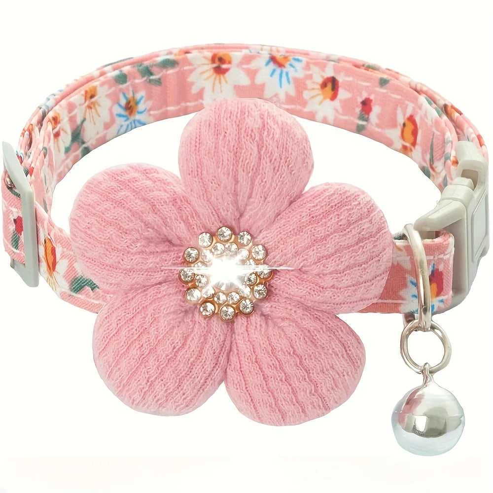 Pink floral cat collar with a large fabric flower attachment featuring a central rhinestone and a small silver bell