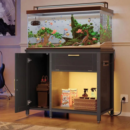 Fish tank on a dark grey cabinet with open storage containing fish food and supplies