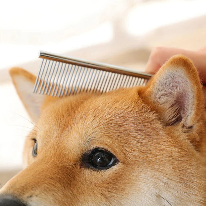 Stainless steel pet grooming and dematting comb brushing the fur of a dog