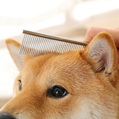 Stainless steel pet grooming and dematting comb brushing the fur of a dog