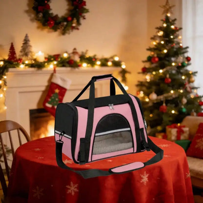 Pink and black pet carrier bag on a table with Christmas decorations