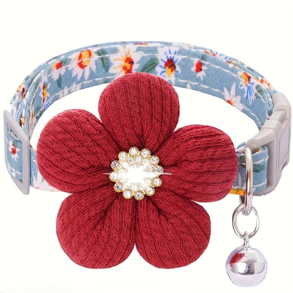 Blue floral cat collar with a large red fabric flower and a silver bell